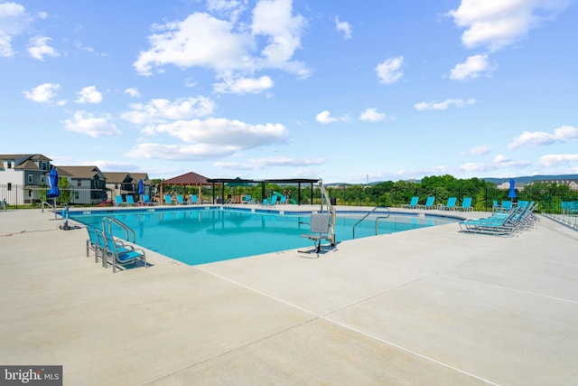 community pool featuring fence and a patio