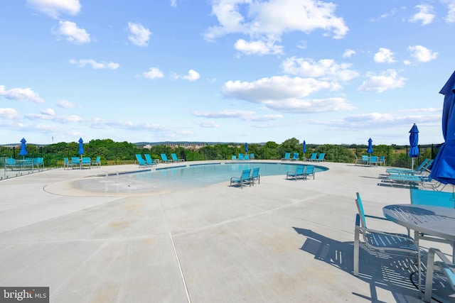 community pool featuring a patio and fence