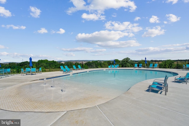 community pool featuring fence and a patio area