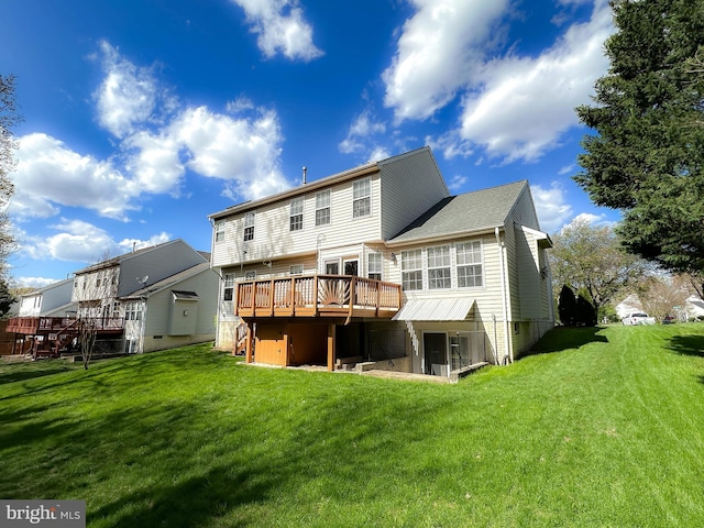 rear view of property with a wooden deck and a lawn