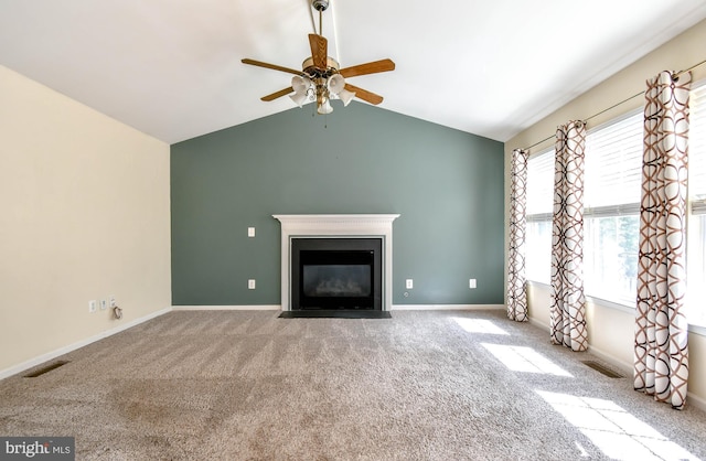 unfurnished living room with a fireplace with flush hearth, vaulted ceiling, visible vents, a ceiling fan, and carpet floors