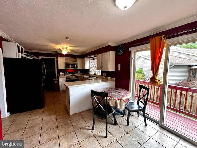 kitchen with a peninsula, crown molding, appliances with stainless steel finishes, and light tile patterned floors