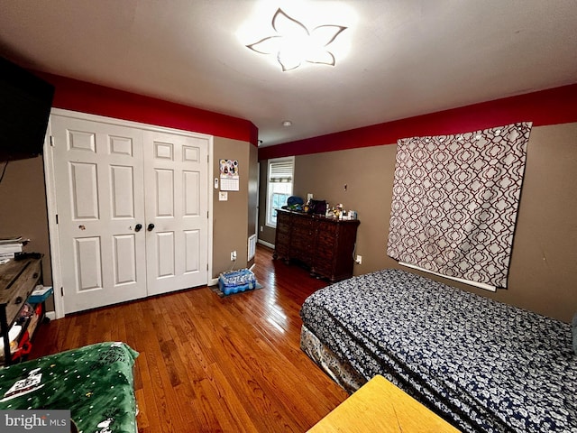bedroom with wood finished floors and a closet