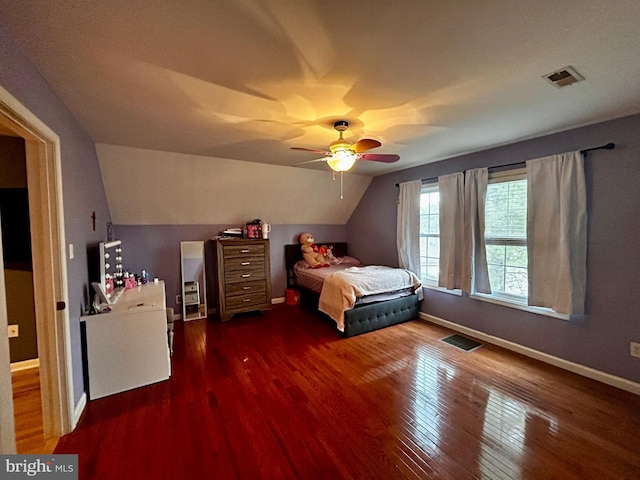 bedroom featuring visible vents, baseboards, vaulted ceiling, and wood finished floors