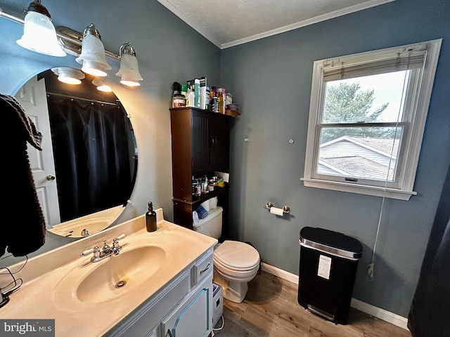 bathroom featuring wood finished floors, vanity, baseboards, toilet, and ornamental molding