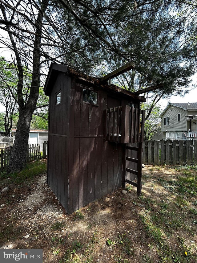 view of outbuilding with fence and an outbuilding