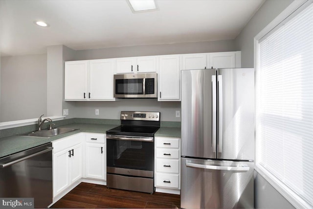 kitchen with dark wood-style flooring, recessed lighting, appliances with stainless steel finishes, white cabinetry, and a sink