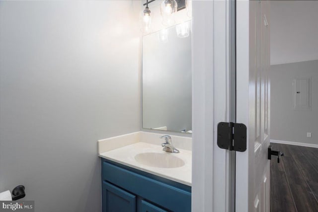 bathroom featuring baseboards, wood finished floors, and vanity
