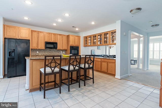 2804 Persimmon Pl Unit D3, Cambridge, MD 21613 - kitchen with black appliances, ornate columns, decorative backsplash, light colored carpet, and light tile patterned flooring