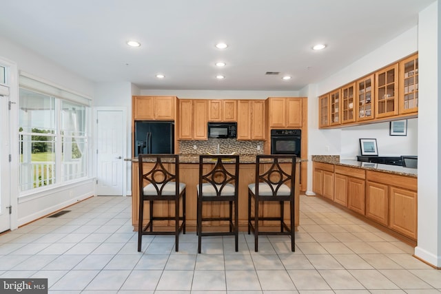 2804 Persimmon Pl Unit D3, Cambridge, MD 21613 - kitchen with a kitchen breakfast bar, glass insert cabinets, backsplash, visible vents, and black appliances