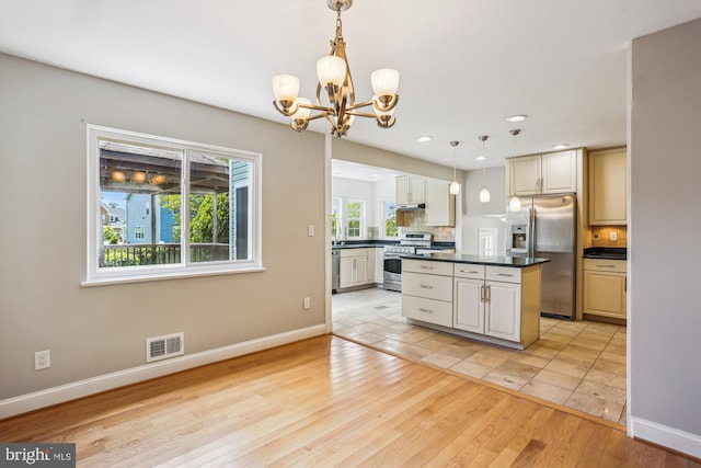 19916 Westerly Ave, Poolesville, MD 20837 - kitchen with appliances with stainless steel finishes, dark countertops, a chandelier, tasteful backsplash, and under cabinet range hood