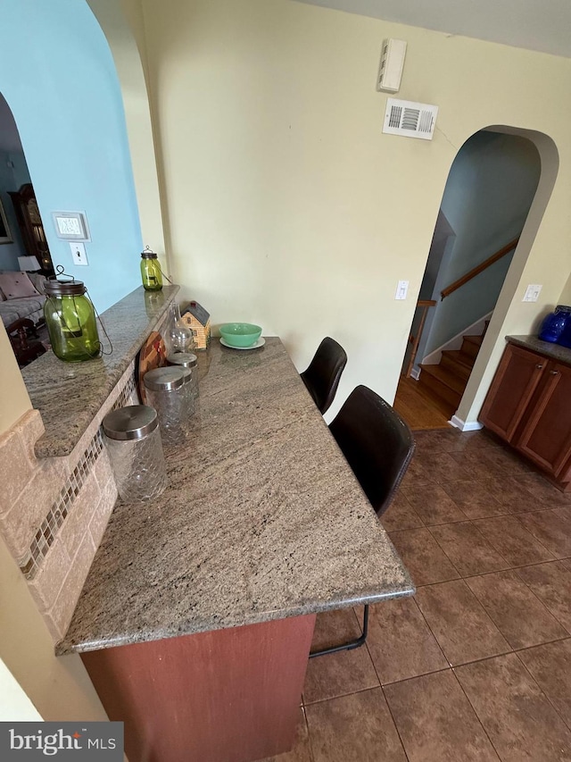 2703 Branch Pike, Cinnaminson, NJ 08077 - dining space featuring dark tile patterned flooring, arched walkways, visible vents, and stairs