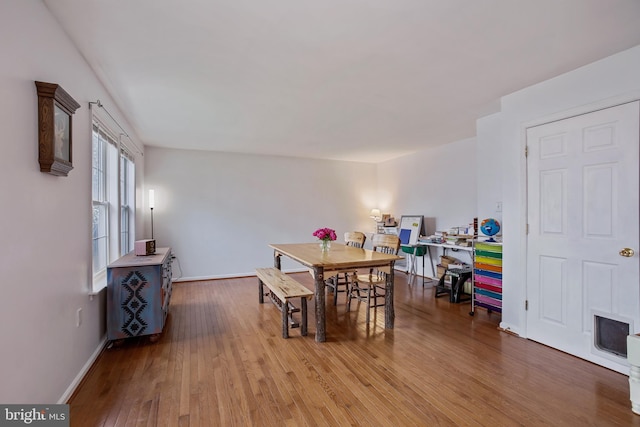 dining room with baseboards and hardwood / wood-style floors