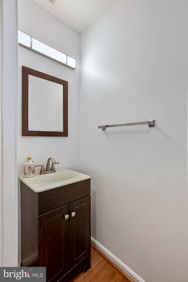 bathroom featuring vanity, baseboards, and wood finished floors