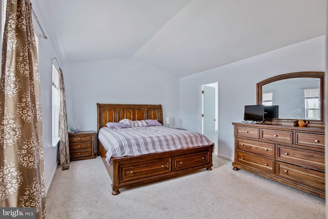bedroom featuring baseboards, lofted ceiling, and light carpet
