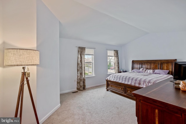 carpeted bedroom featuring baseboards, lofted ceiling, and visible vents
