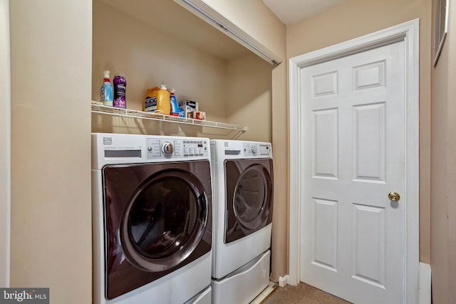 clothes washing area featuring carpet, laundry area, and washer and clothes dryer