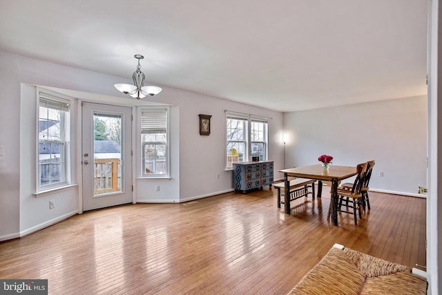 dining room with baseboards, hardwood / wood-style flooring, and an inviting chandelier