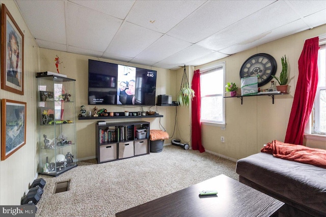 living room featuring a paneled ceiling, carpet flooring, visible vents, and a wealth of natural light