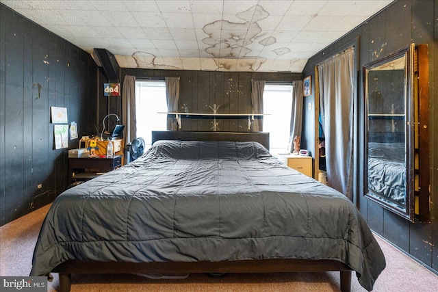 carpeted bedroom featuring wood walls