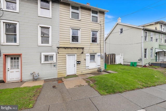 townhome / multi-family property with a front lawn