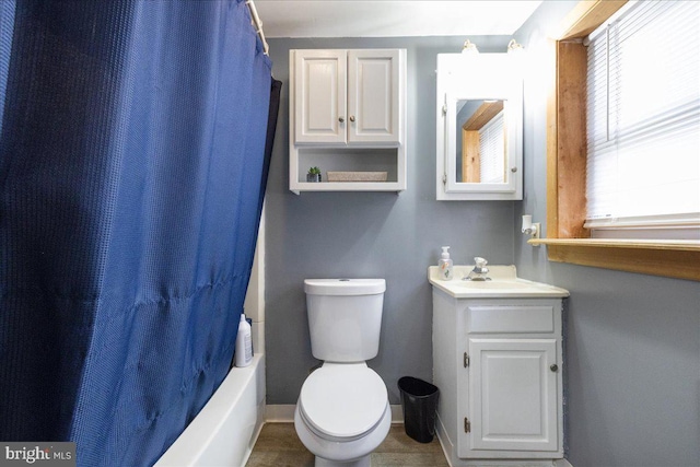full bath featuring toilet, vanity, and baseboards