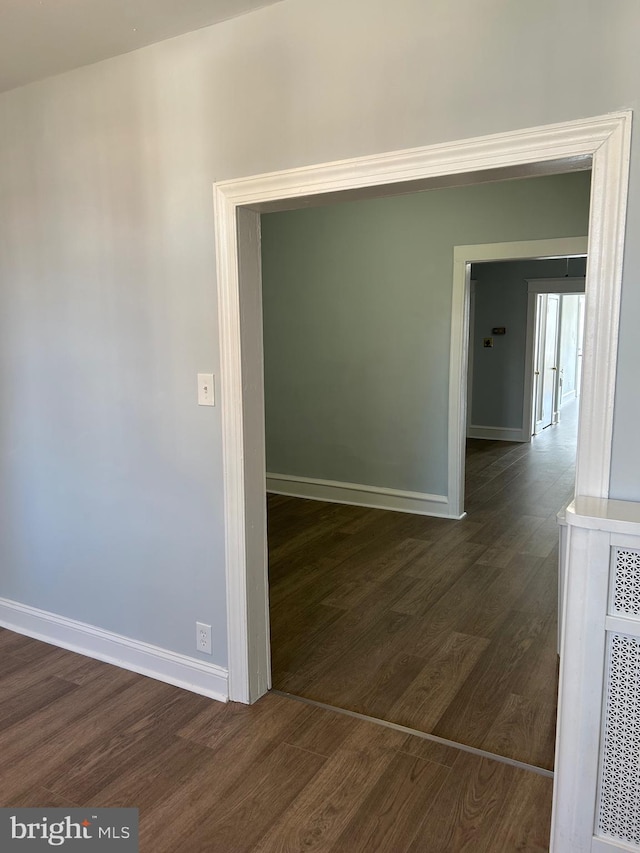 hallway with baseboards and dark wood-style floors