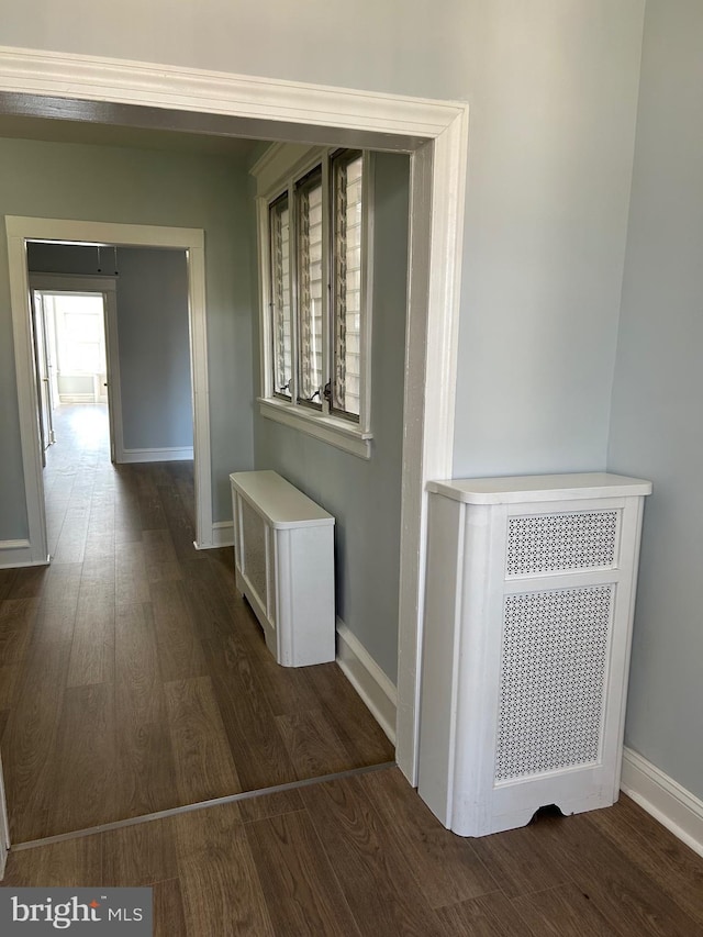 hall featuring dark wood finished floors and baseboards