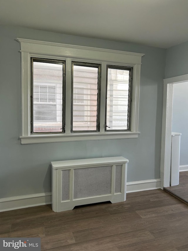 interior details featuring radiator heating unit, baseboards, and wood finished floors
