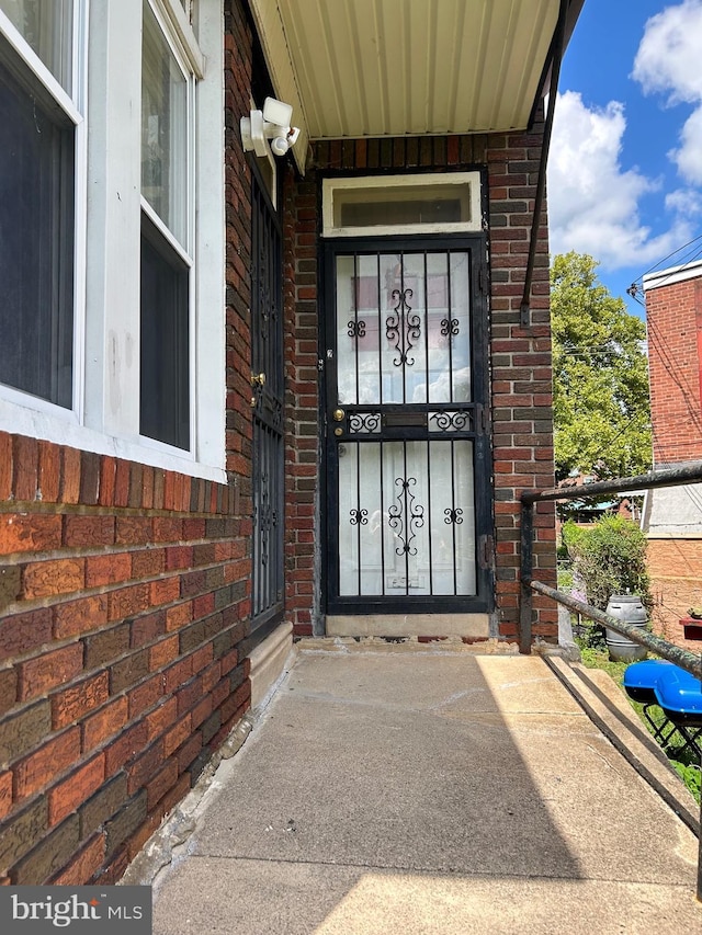 doorway to property featuring brick siding