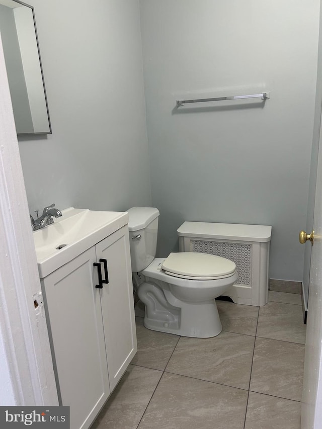bathroom featuring radiator heating unit, toilet, vanity, and tile patterned floors