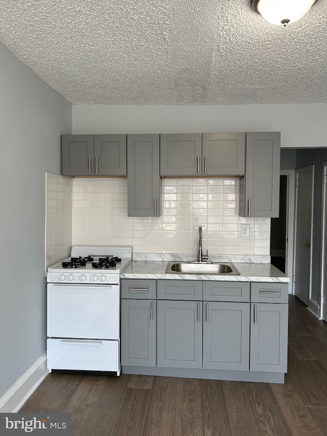 kitchen with gas range gas stove, gray cabinetry, and a sink