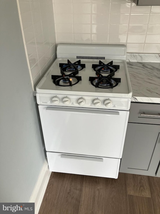 room details featuring light countertops, wood finished floors, and white gas range