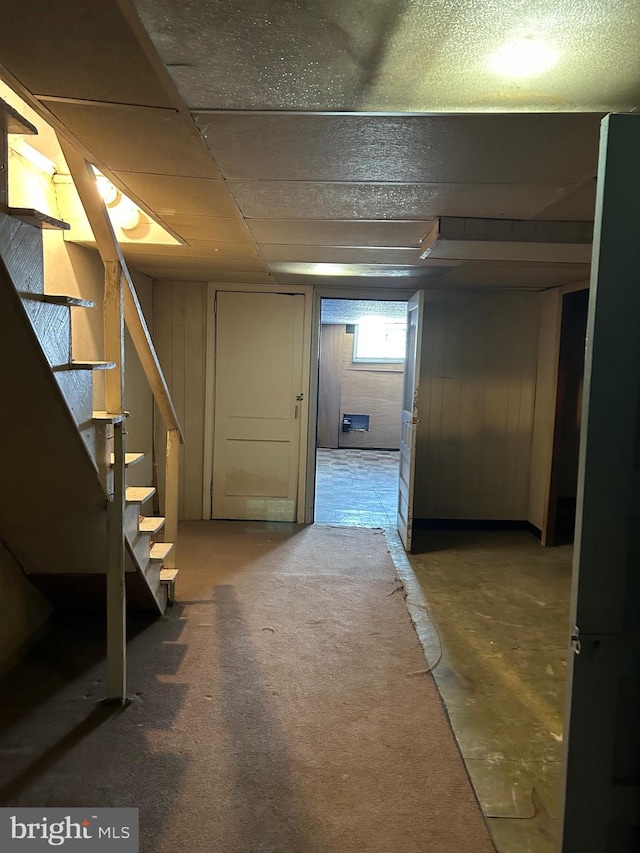 below grade area featuring a drop ceiling and stairway