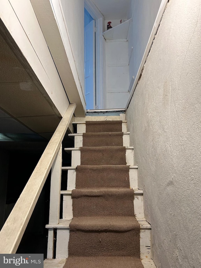 stairs featuring a textured wall