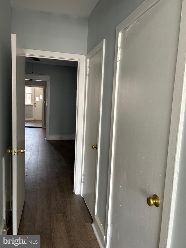 hallway with baseboards and wood finished floors