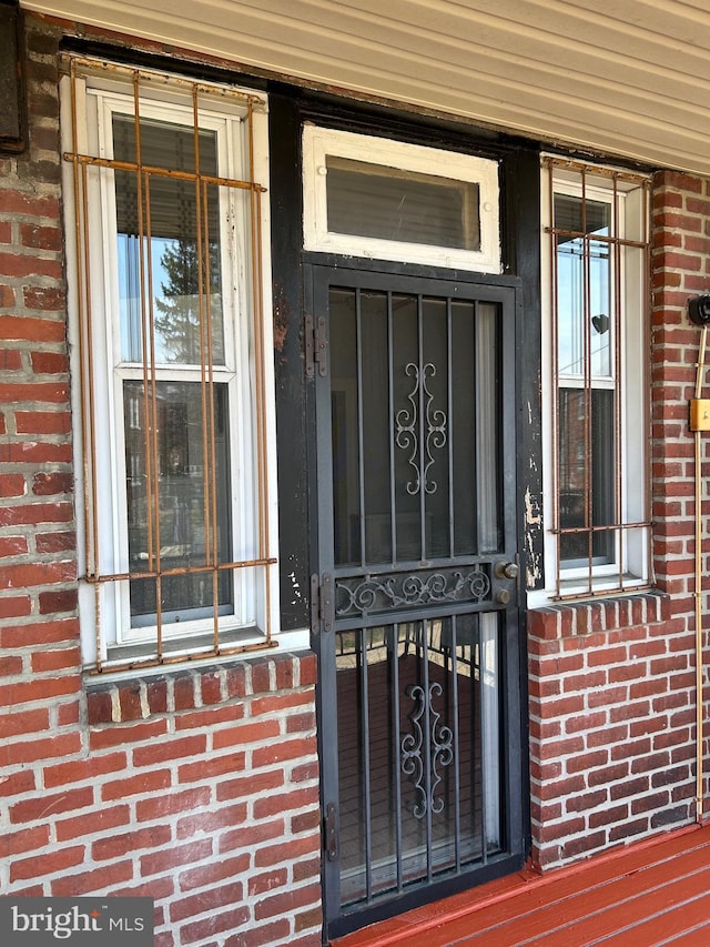 entrance to property featuring brick siding