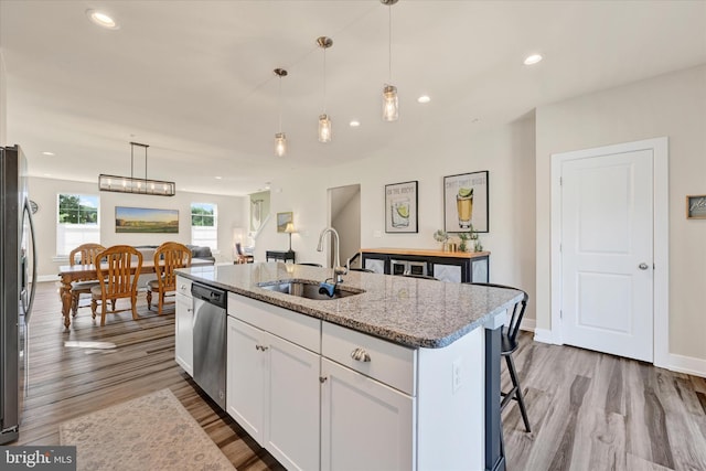 10031 Whitaker Way, Parkville, MD 21234 - kitchen with light stone countertops, an island with sink, white cabinets, a sink, and appliances with stainless steel finishes