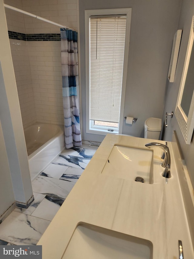 bathroom with vanity, shower / bath combination with curtain, marble finish floor, and toilet