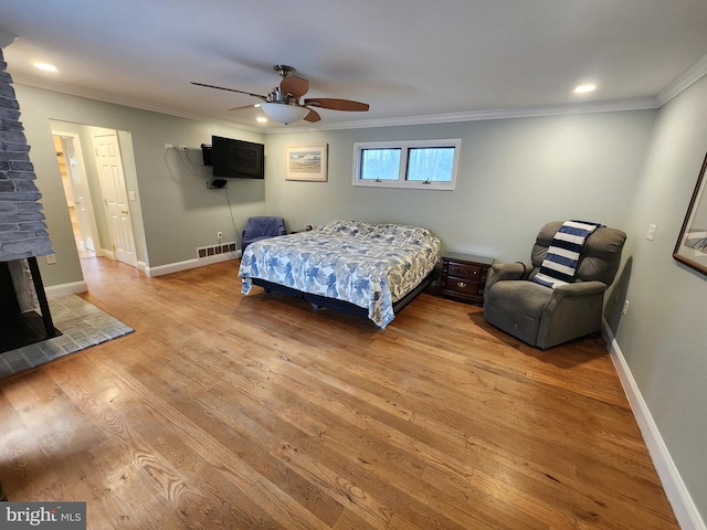 bedroom featuring a ceiling fan, light wood-type flooring, ornamental molding, and visible vents
