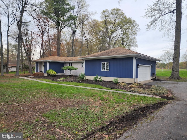 ranch-style home featuring a garage, driveway, and a front lawn