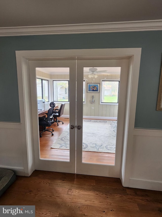 doorway to outside with french doors, wood finished floors, and ornamental molding