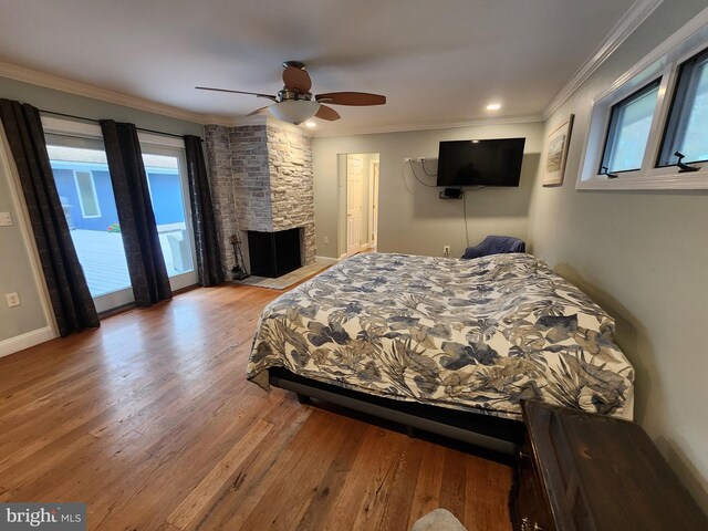 bedroom featuring wood finished floors, ornamental molding, multiple windows, and access to exterior