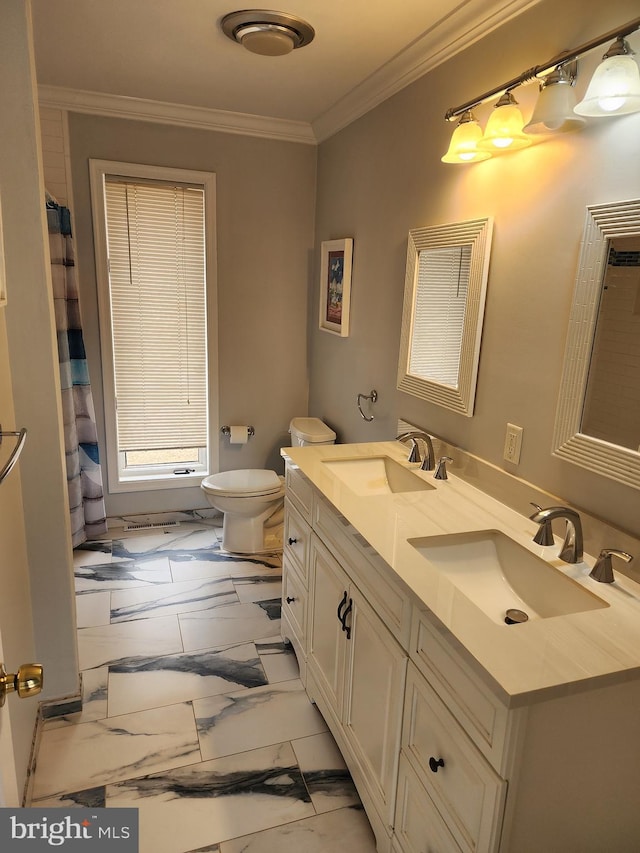 full bathroom with toilet, double vanity, a sink, and ornamental molding