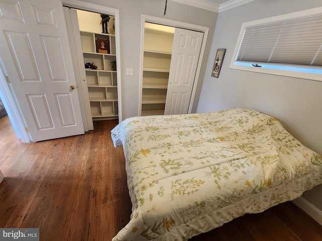 bedroom featuring crown molding, wood finished floors, and baseboards