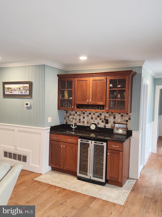 bar with wine cooler, visible vents, light wood finished floors, and crown molding