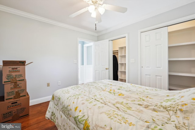 bedroom featuring multiple closets, wood finished floors, ornamental molding, baseboards, and ceiling fan