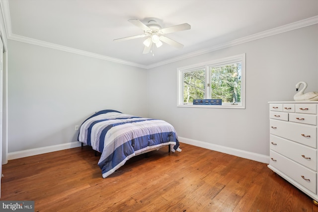 bedroom with a ceiling fan, baseboards, ornamental molding, and wood finished floors