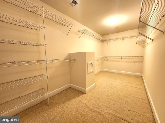 walk in closet featuring visible vents and carpet