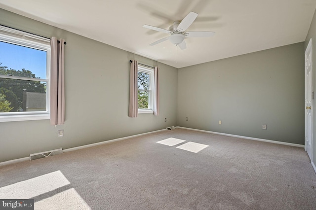 unfurnished room with ceiling fan, visible vents, baseboards, and carpet